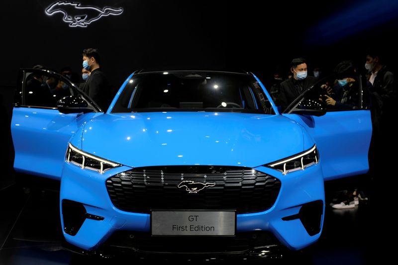 &copy; Reuters. FILE PHOTO: Visitors check on a Ford Mustang Mach-E electric vehicle displayed at a launch event in Shanghai, China April 13, 2021. REUTERS/Yilei Sun/File Photo