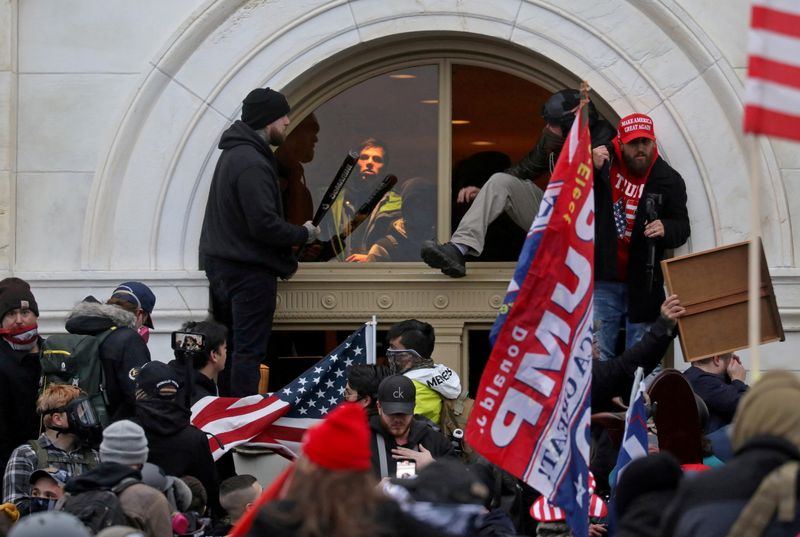 © Reuters. FILE PHOTO: A mob of supporters of then-U.S. President Donald Trump climb through a window they broke as they storm the U.S. Capitol Building in Washington, U.S., January 6, 2021. REUTERS/Leah Millis/File Photo