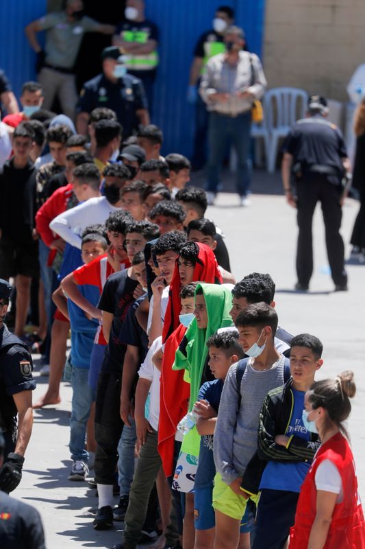 © Reuters. أطفال مغاربة يصطفون في طابور أمام مؤسسة للحصول على طعام في مدينة سبتة باسبانيا يوم 19 مايو ايار 2021. تصوير:رويترز.