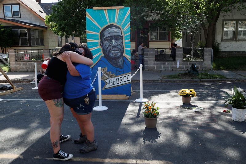 © Reuters. People embrace as they attend a Celebration of Life festival in honor of George Floyd, who was killed by Minneapolis police one year ago, at George Floyd Square in south Minneapolis, Minnesota, U.S., May 25, 2021. REUTERS/Eric Miller