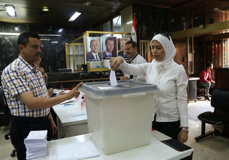 Syria's Assad votes in former rebel town, site of chemical attack