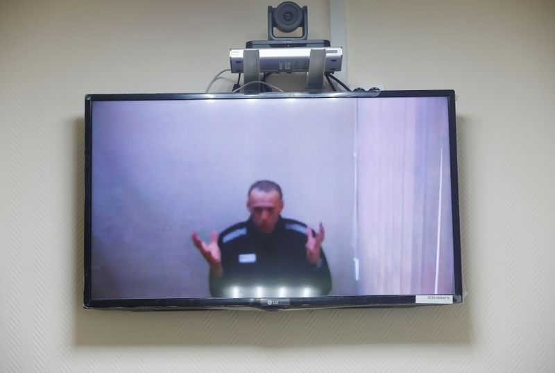 &copy; Reuters. Russian opposition leader Alexei Navalny is seen on a screen via a video link during a hearing to consider his lawsuits against the penal colony over detention conditions there, at the Petushki district court in Petushki, Russia May 26, 2021. REUTERS/Maxi