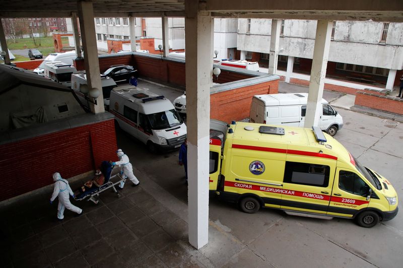 &copy; Reuters. Medical specialists wearing protective gear transfer a patient as ambulances queue outside a hospital, amid the outbreak of the coronavirus disease (COVID-19) in Saint Petersburg, Russia November 11, 2020.  REUTERS/Anton Vaganov
