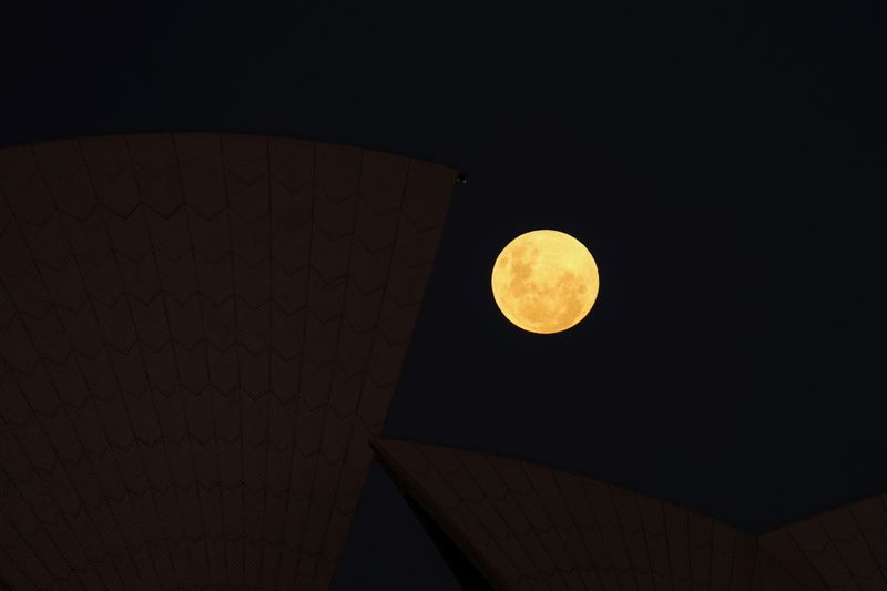 &copy; Reuters. A Super Flower Moon rises behind the Sydney Opera House on the night of a lunar eclipse, in Sydney, Australia, May 26, 2021.  REUTERS/Loren Elliott